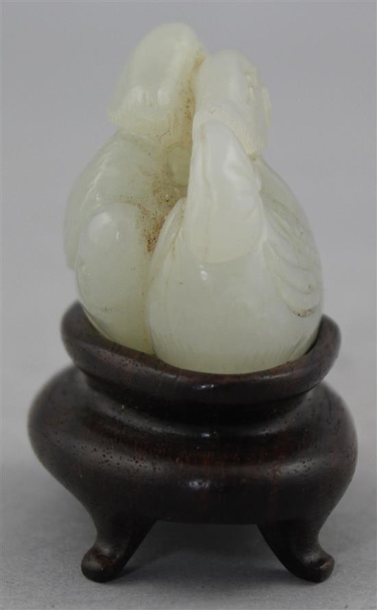 A Chinese white jade carving of two mandarin ducks, 18th / 19th century, 4.8cm., wood stand